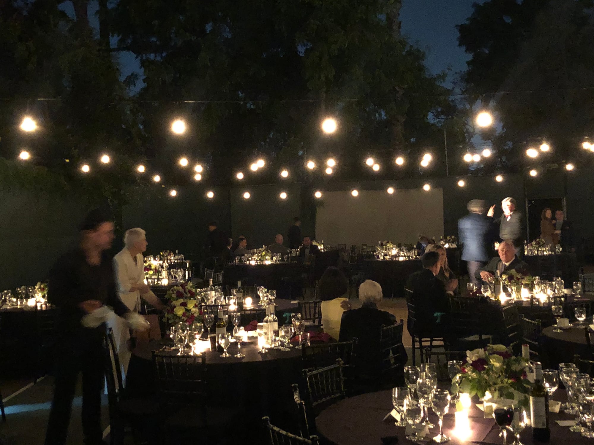 Candlelit tables arranged along the grounds for the gala dinner
