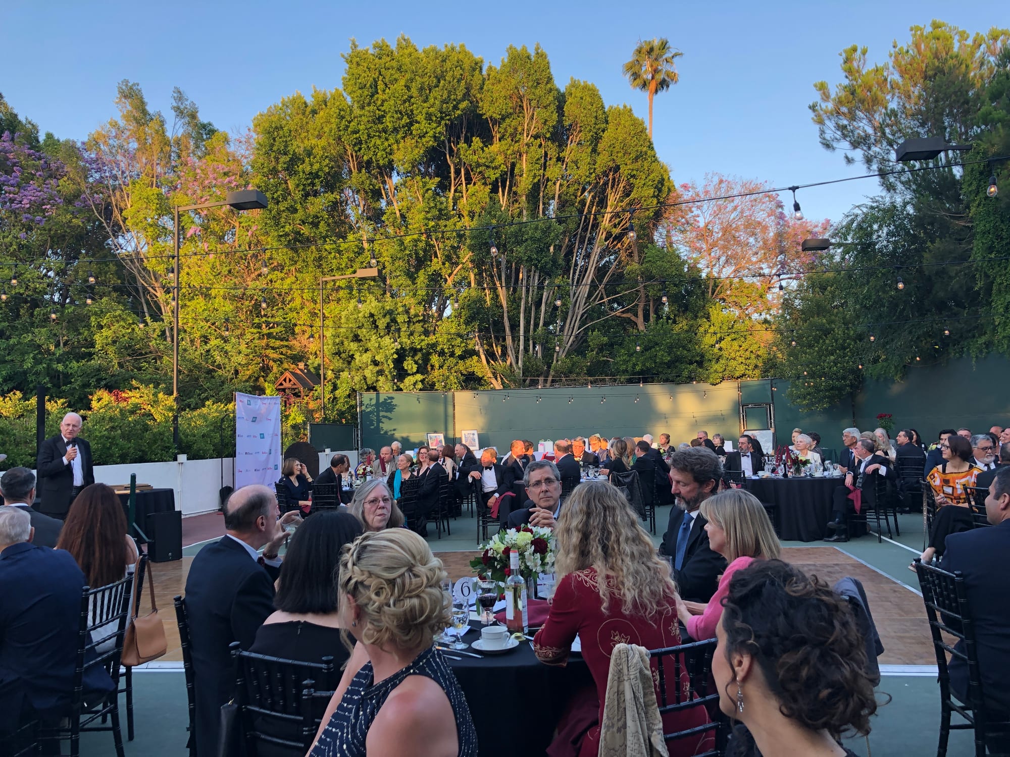 Guests at cocktail hour and dinner seating on the grounds at golden hour