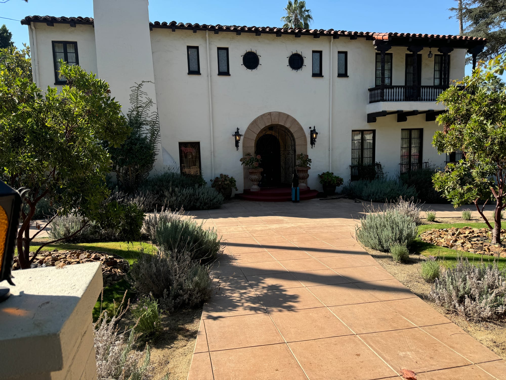 Arched front entrance and white stucco facade of the Spanish Colonial Revival estate