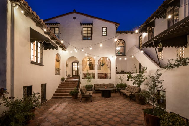 Arched courtyard strung with lights in the evening
