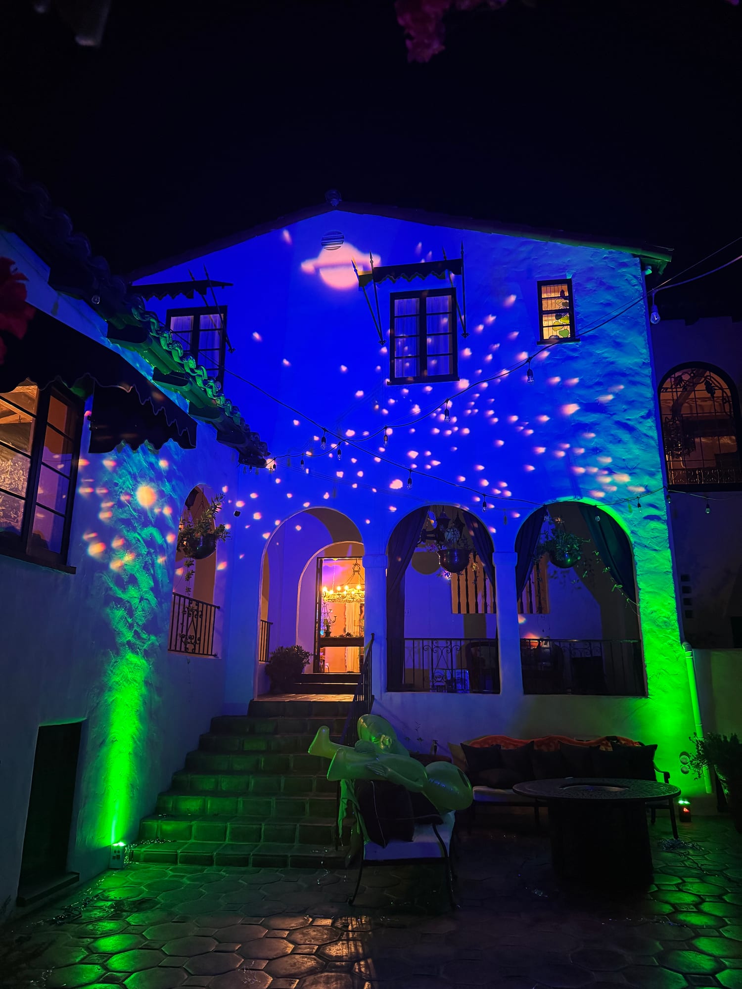 Estate facade lit with colorful event lighting at night