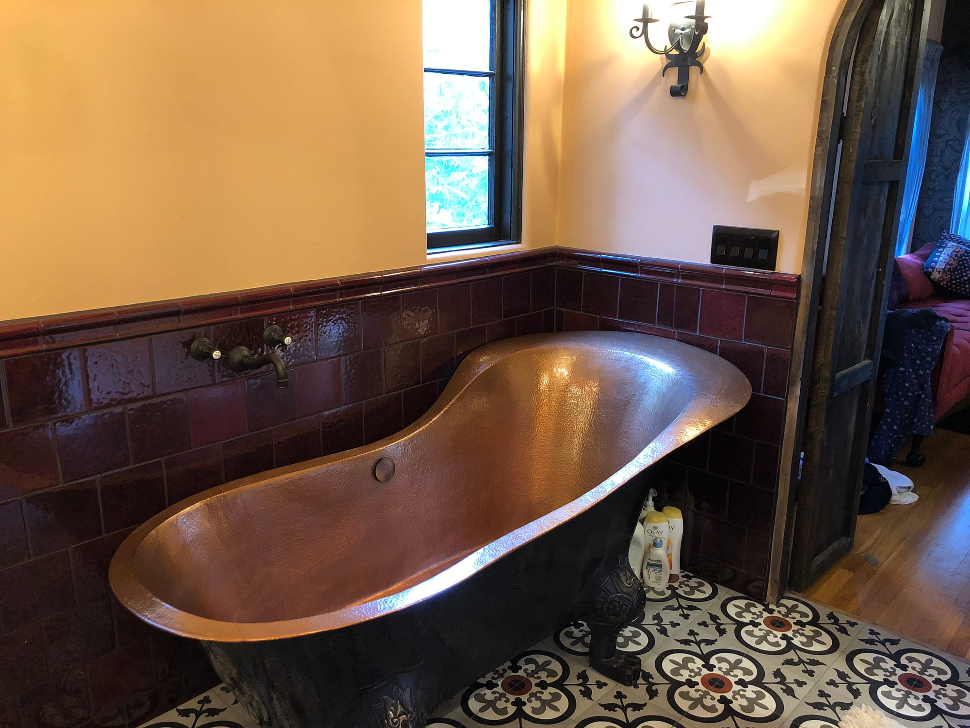 Copper soaking tub in a patterned-tile bathroom