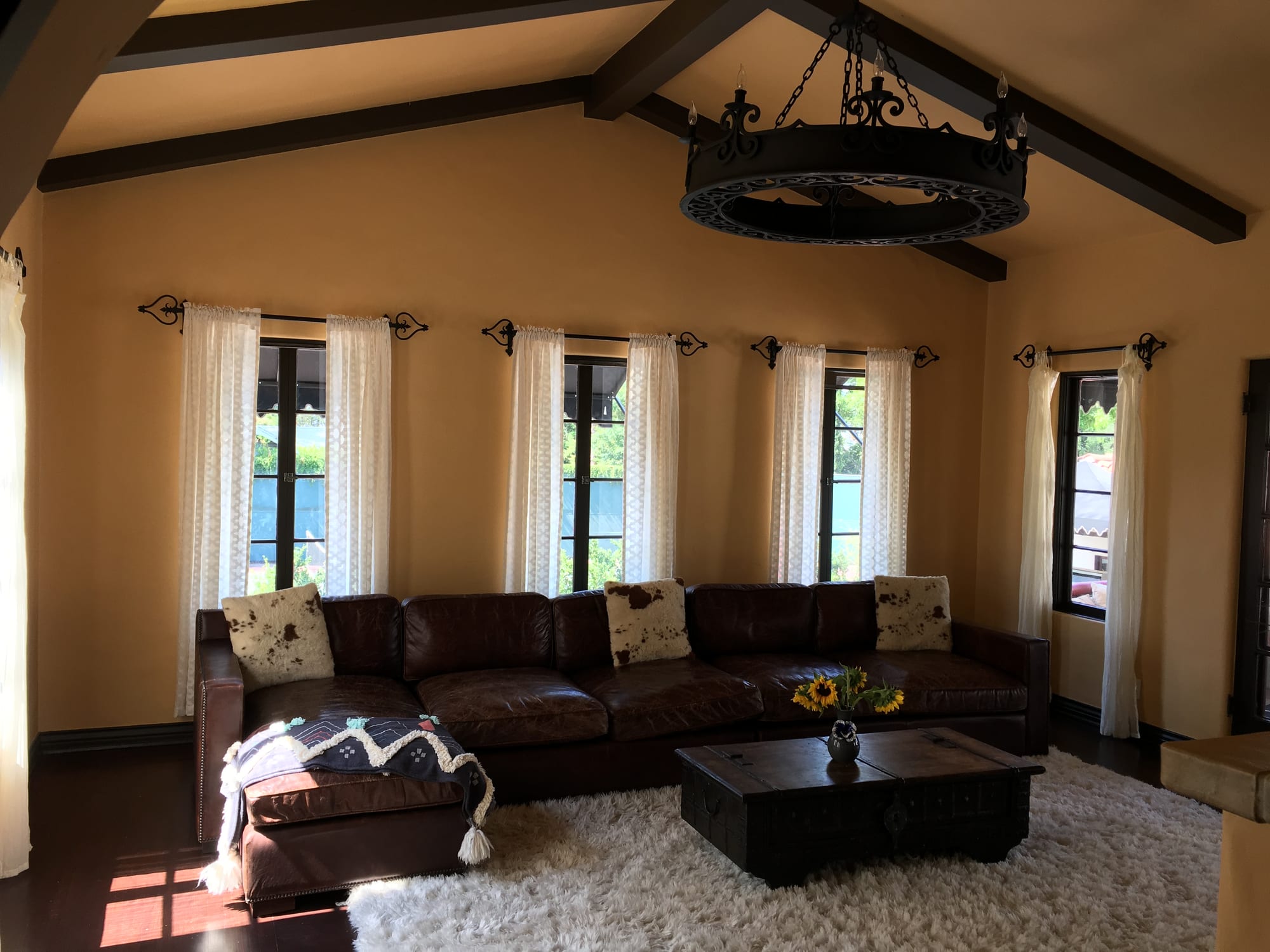 Sitting room with a beamed cathedral ceiling and wrought-iron chandelier