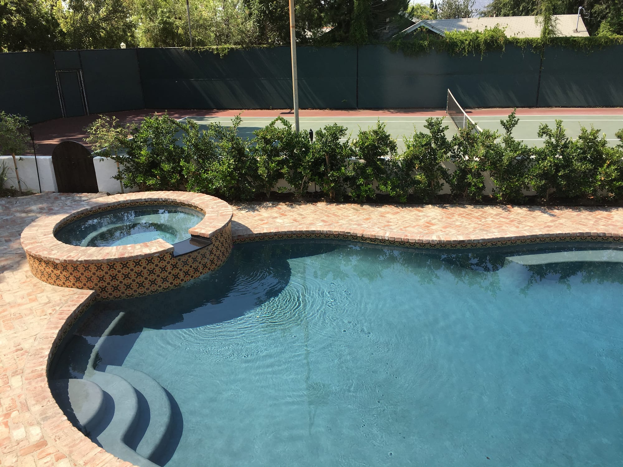 Pool and circular tiled spa on a sunny afternoon