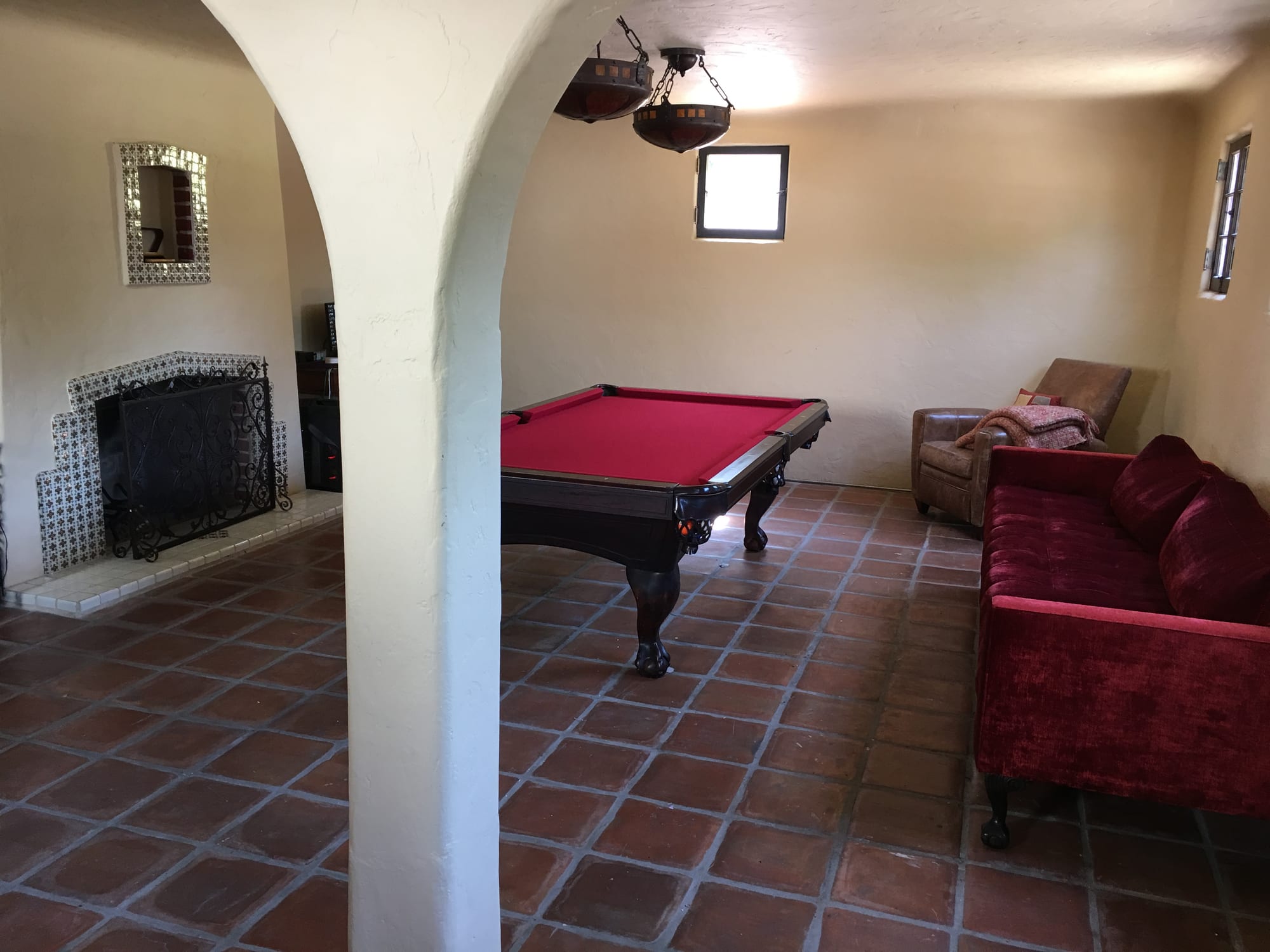 Game room with a pool table, fireplace, and Saltillo-tiled floor