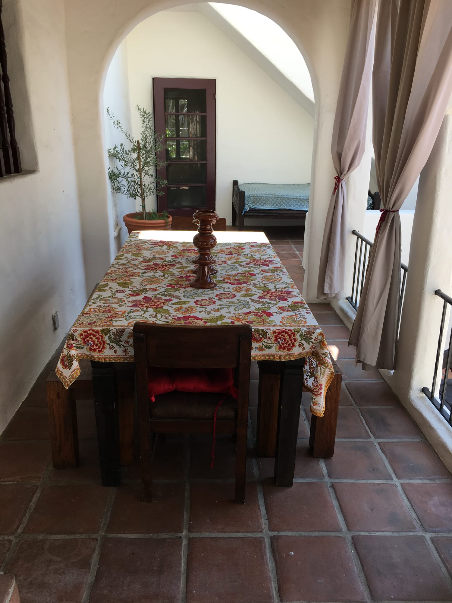 Dining table set beneath draped windows