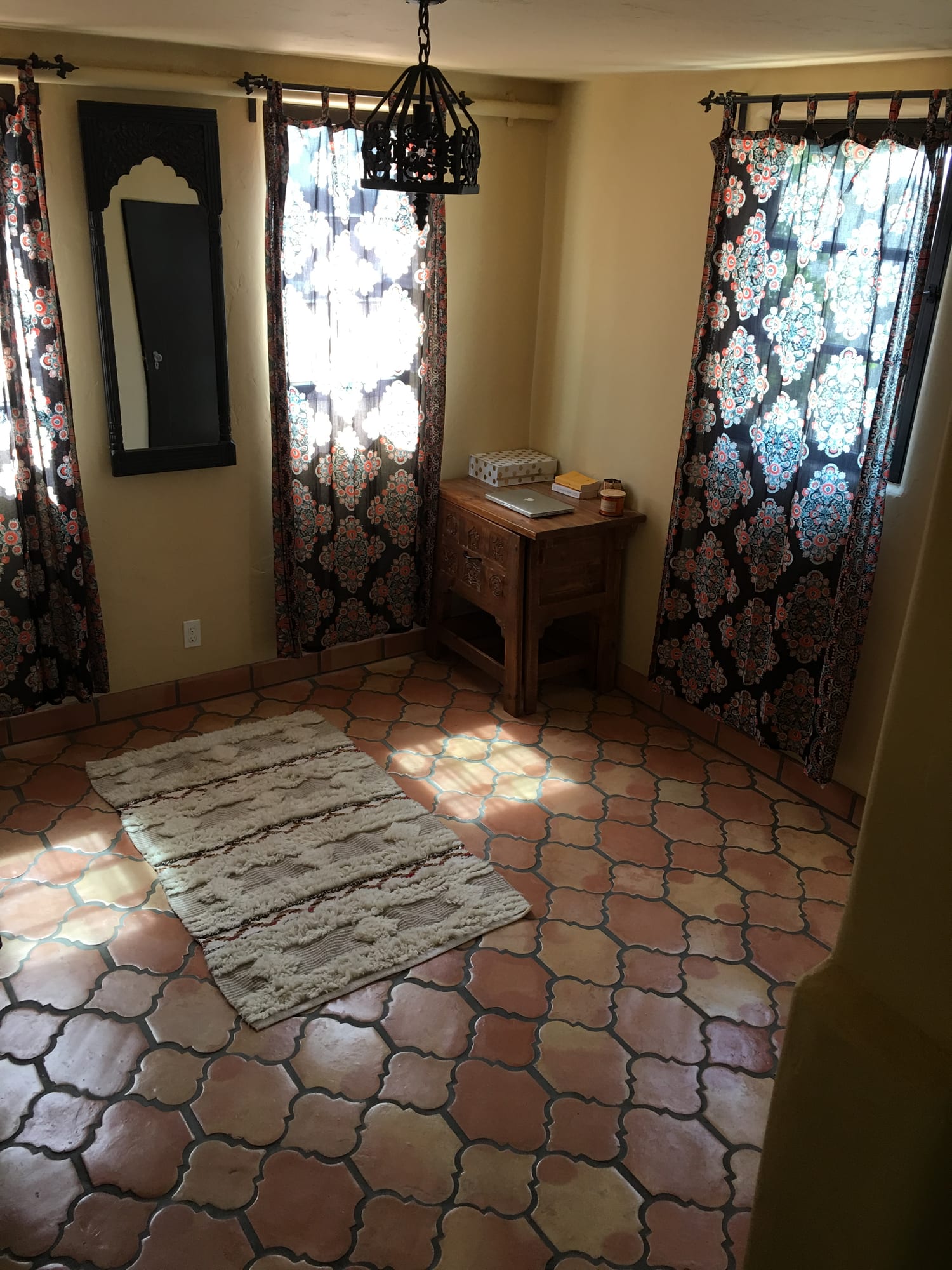 Sitting area with patterned drapery and a Saltillo-tiled floor